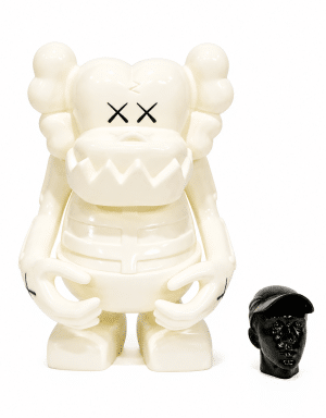 A cream-colored KAWS Companion figure with "XX" eyes stands next to a small, glossy black head wearing a cap.