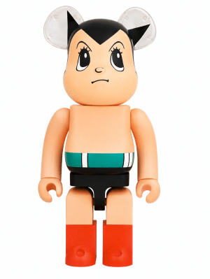 Astro Boy Be@rbrick figure with black hair, clear ears, a teal and white striped belt, black shorts, and red boots.