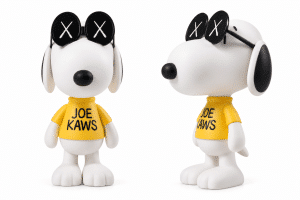 Two white Snoopy figurines with black ears, noses, and "X" sunglasses wear yellow "JOE KAWS" shirts.