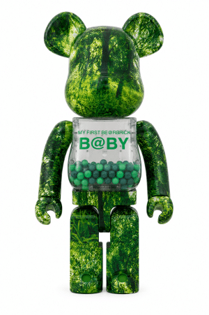 A green, forest-patterned Bearbrick toy with a clear torso containing green balls and "MY FIRST BE@RBRICK B@BY" text.