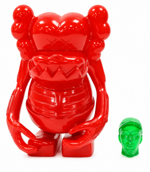 A shiny red KAWS Companion figure with "XX" eyes stands next to a small, translucent green head.