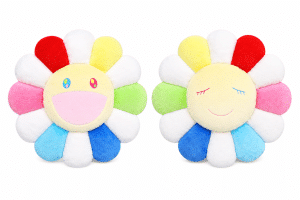 Two plush flower pillows with yellow faces and colorful petals, one smiling with open eyes, the other with closed eyes.