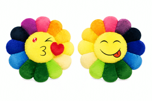 Two colorful flower pillows with yellow faces, one winking and blowing a kiss, the other sticking its tongue out.
