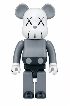 A KAWS Companion toy, styled like Mickey Mouse, stands with a light gray head and dark gray body.