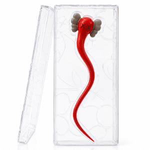 A red, worm-like figure with X-eyes and gray ears is encased in a clear plastic box with a lid.