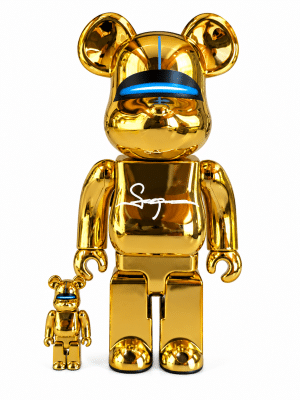 Two shiny gold Bearbrick figures, one large and one small, with blue visors and "Sg" on the chest.