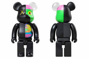 A front and back view of a black bear-shaped toy, with the left half of the front showing colorful internal organs and a green face with a yellow "X" eye.