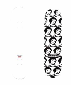 Two white skateboards; one has a "Supreme" logo, the other has a repeated Snow White pattern and a "Supreme" logo.