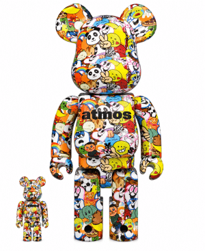 Two Bearbrick figures, one large and one small, are covered in colorful cartoon stickers with "atmos" on their chests.