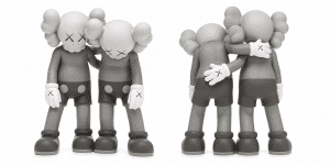 Two grayscale KAWS Companion figures stand side-by-side, one with an arm around the other's shoulder.