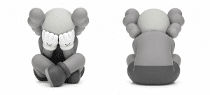 A gray KAWS Companion figure sits with its hands over its face, and another identical figure is shown from the back.