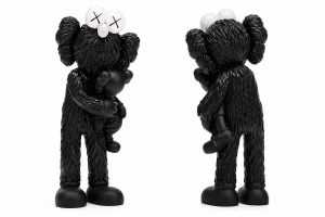 Two black KAWS Companion figures stand against a white background, each holding a smaller black figure.