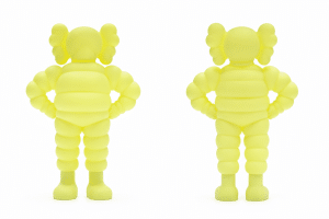 Two identical neon yellow Michelin Man figurines with "X" eyes, one facing forward and one facing backward.
