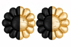 Two plush sunflower pillows, each split vertically with one half black and the other metallic gold.